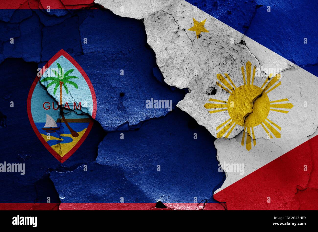 Flaggen von Guam und den Philippinen auf rissiger Wand gemalt Stockfoto