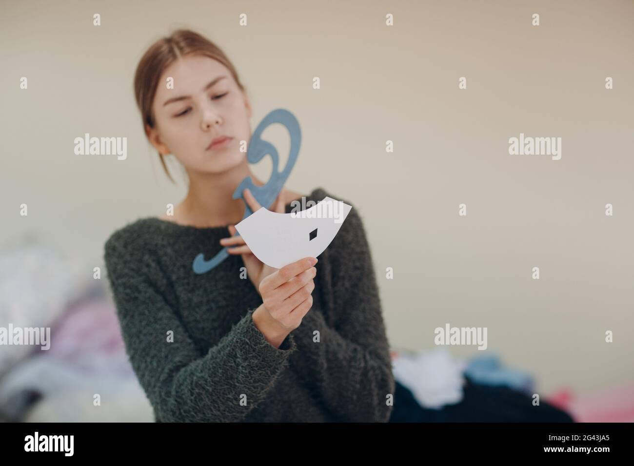 Junge schöne Schneiderin Kleidung Designer mit Muster und Vorlage in Bekleidungsfabrik. Stockfoto