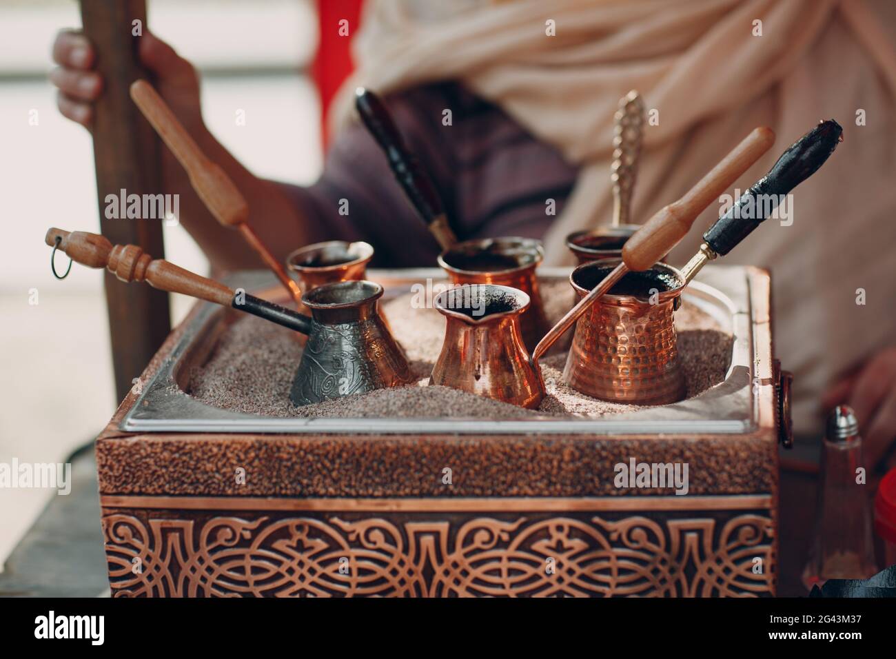 Die Türkischen arabischen Kaffee in den Sand in jezve Stockfoto
