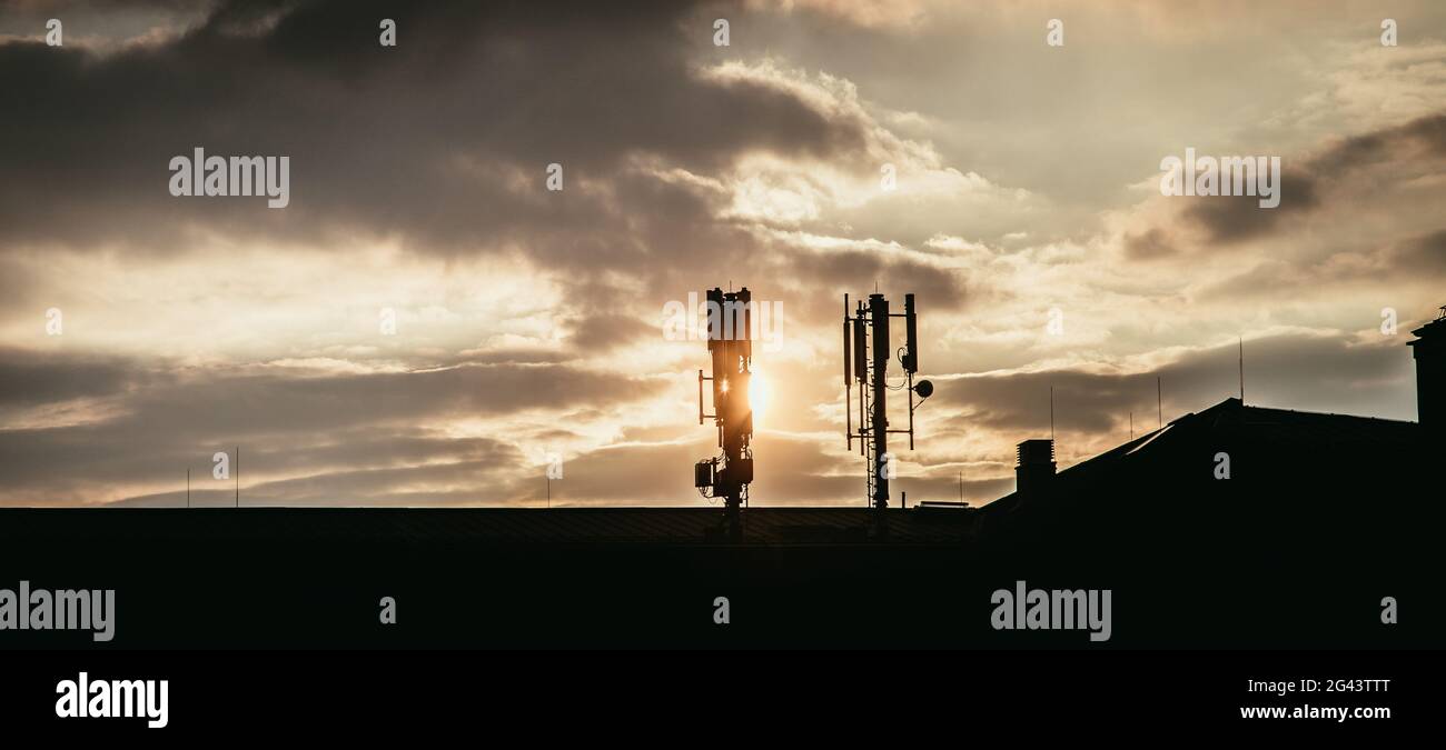 5g und Kommunikationsturm: Silhouette des Kommunikationsturms auf dem Dach, Abend Stockfoto