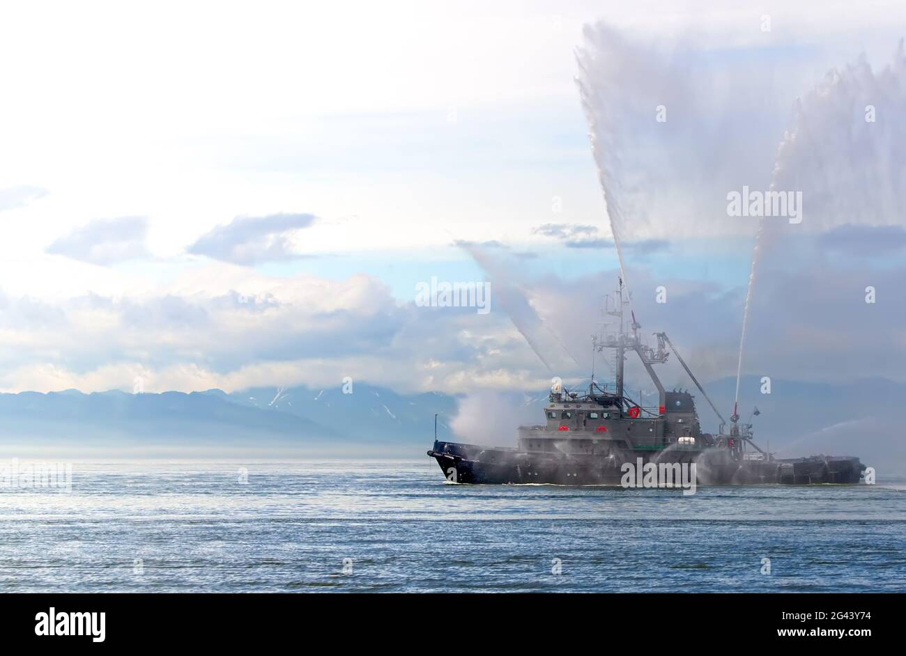 Das schwimmende Schlepper-Boot sprüht Wasserstrahlen Stockfoto