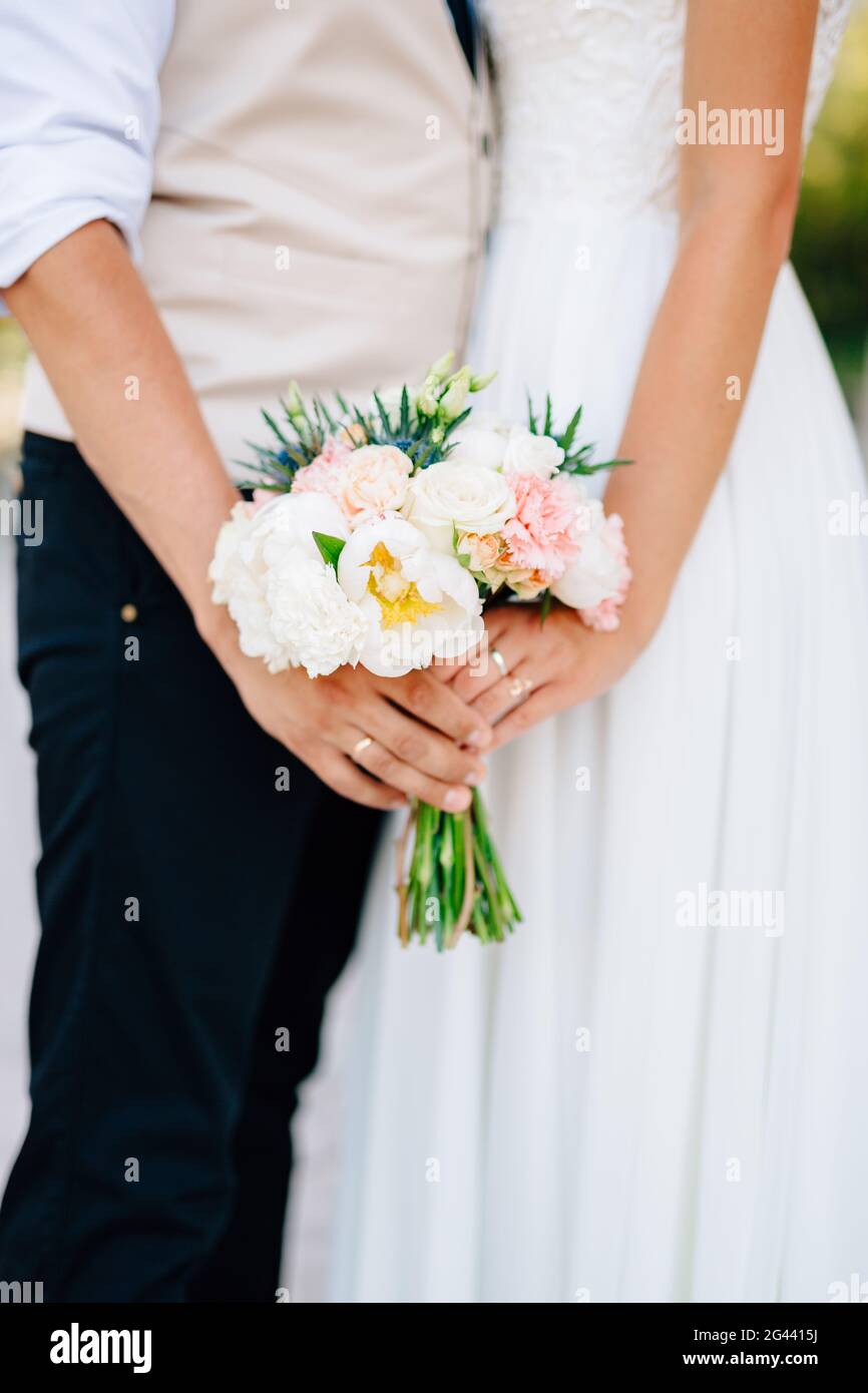 Hände der Braut und Bräutigam hält Hochzeit Blumenstrauß aus nächster Nähe Stockfoto