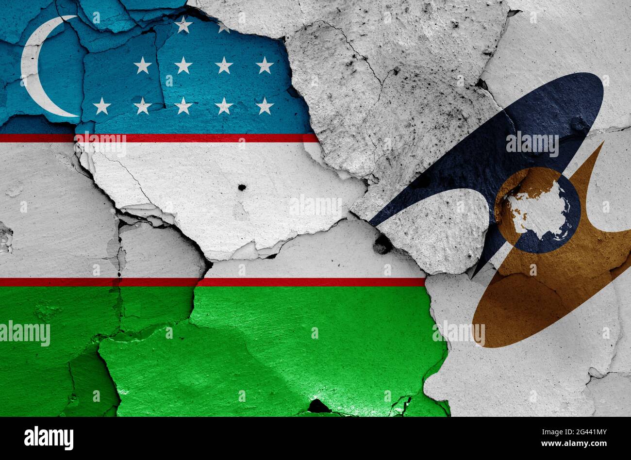 Flaggen Usbekistans und der Eurasischen Wirtschaftsunion, die auf eine rissige Wand gemalt wurden Stockfoto