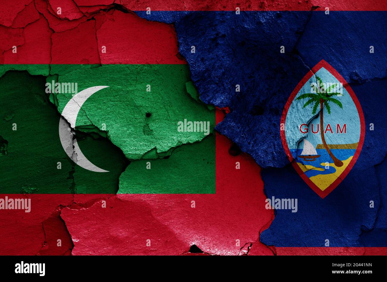 Flaggen von Malediven und Guam auf rissige Wand gemalt Stockfoto
