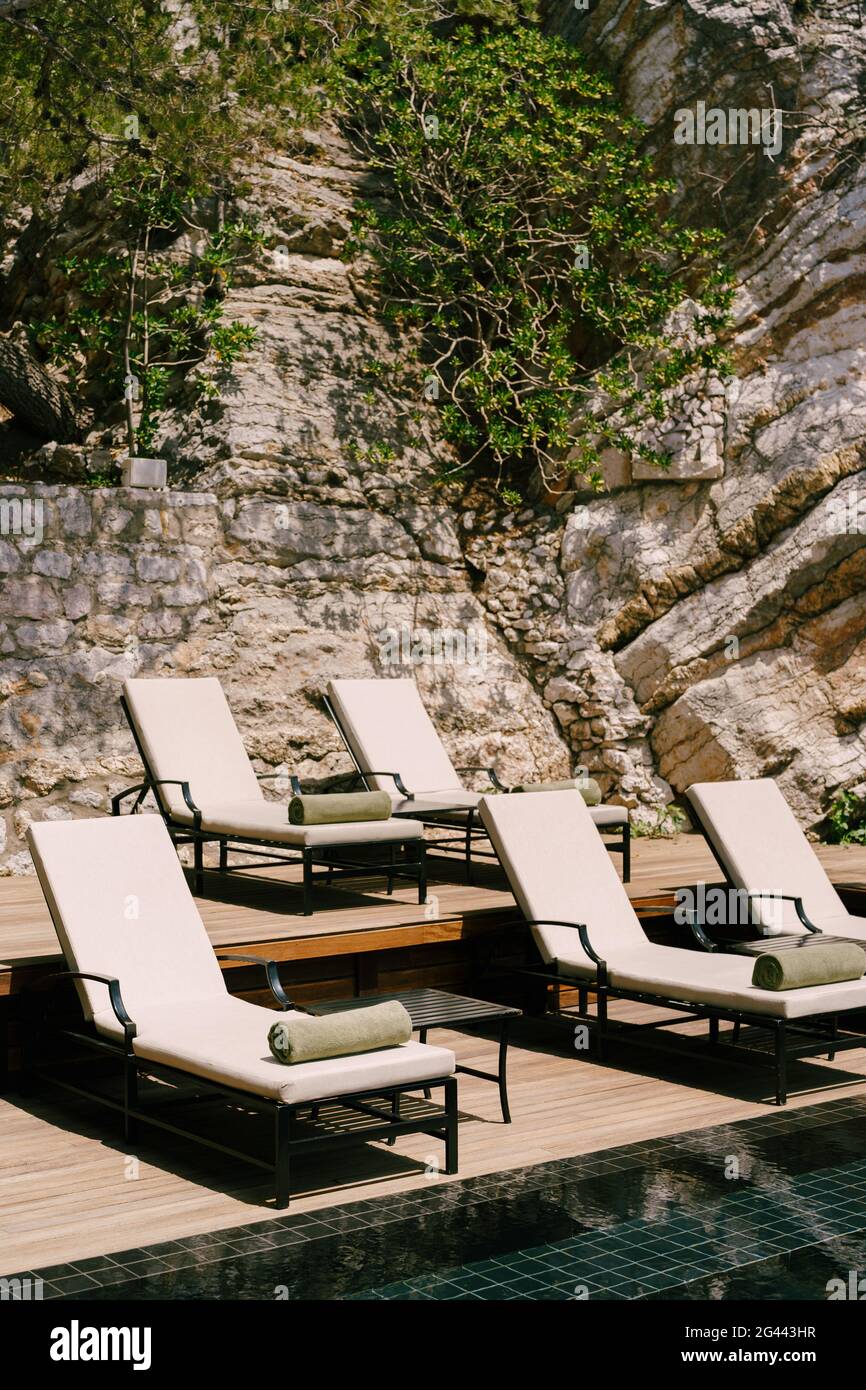 Sonnenliegen am Pool am Fuße des Berges. Stockfoto