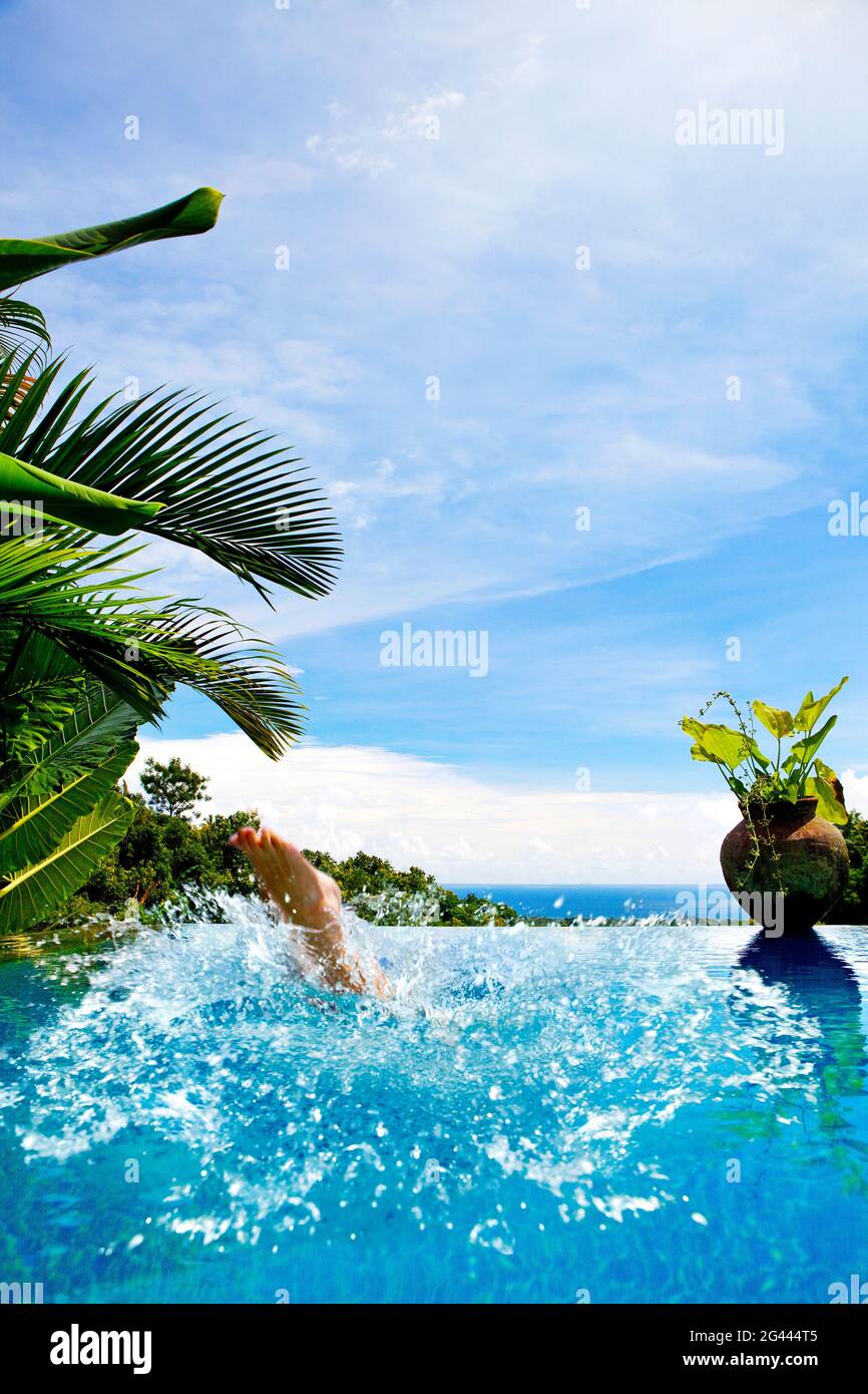 Die Füße der Frau,´s sie in einen Pool spritzt. Bali, Indonesien Stockfoto
