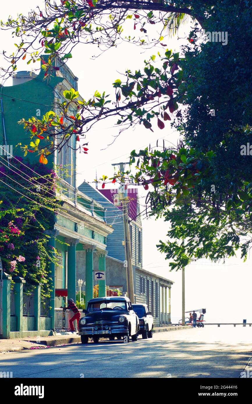 Blick auf die Straße mit bunten Gebäuden, Blumen und einem Oldtimer in Cienfuegos, Kuba Stockfoto