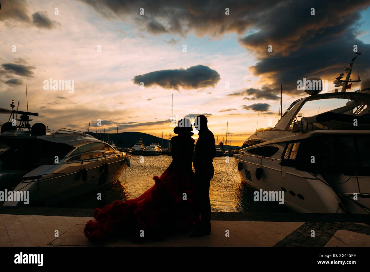 Pärchen umarmen sich bei Sonnenuntergang auf einem Bootssteg Stockfoto