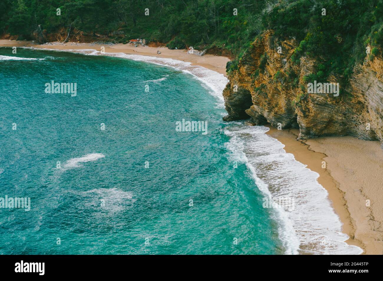 Blick auf den Strand von Mogren in Budva in der Nähe des blauen Meeres Und grüne felsige Berge Stockfoto