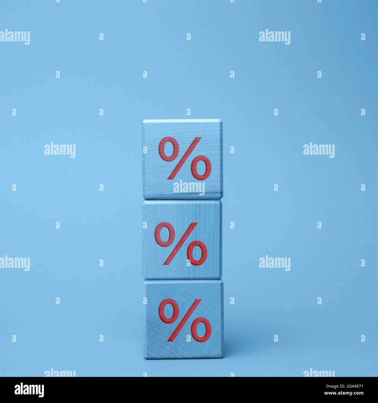 Holzblöcke mit Prozent auf blauem Hintergrund. Das Konzept der Senkung oder Erhöhung der Preise Stockfoto