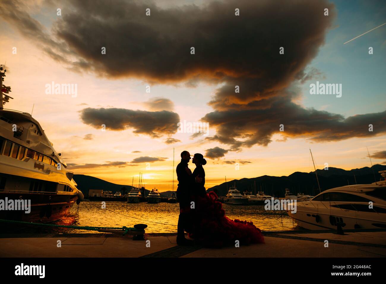 Pärchen umarmen sich bei Sonnenuntergang auf einem Bootssteg Stockfoto
