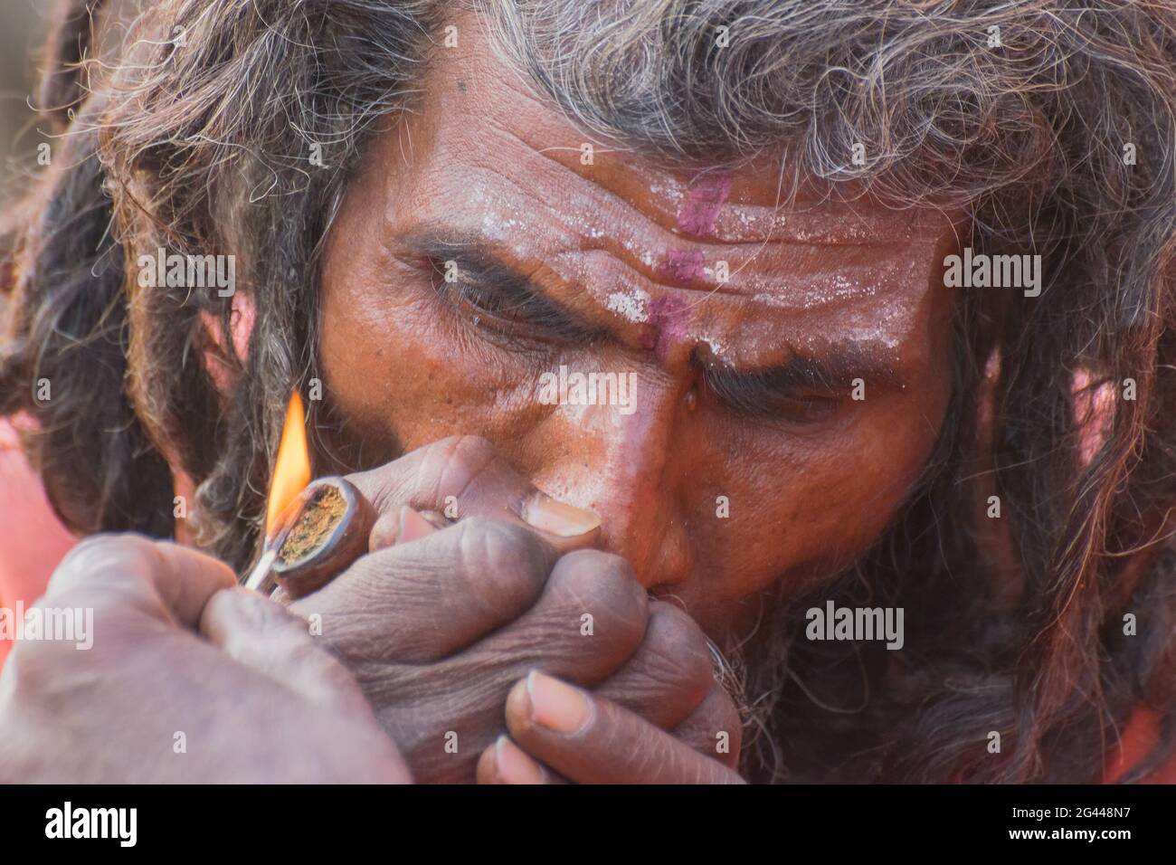 BABUGHAT, KALKUTTA, WESTBENGALEN / INDIEN - 10. JANUAR 2015 : Hindu Sadhu raucht Marihuana, lokal Ganja genannt, eine Form von Canabis sativa . Stockfoto