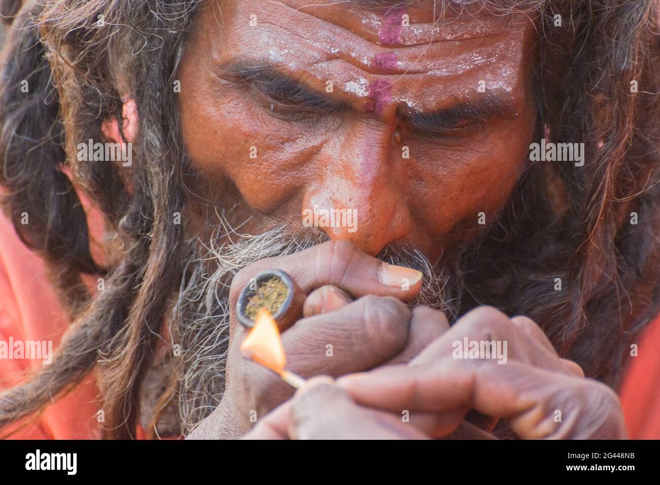 BABUGHAT, KALKUTTA, WESTBENGALEN / INDIEN - 10. JANUAR 2015 : Hindu Sadhu raucht Marihuana, lokal Ganja genannt, eine Form von Canabis sativa . Stockfoto
