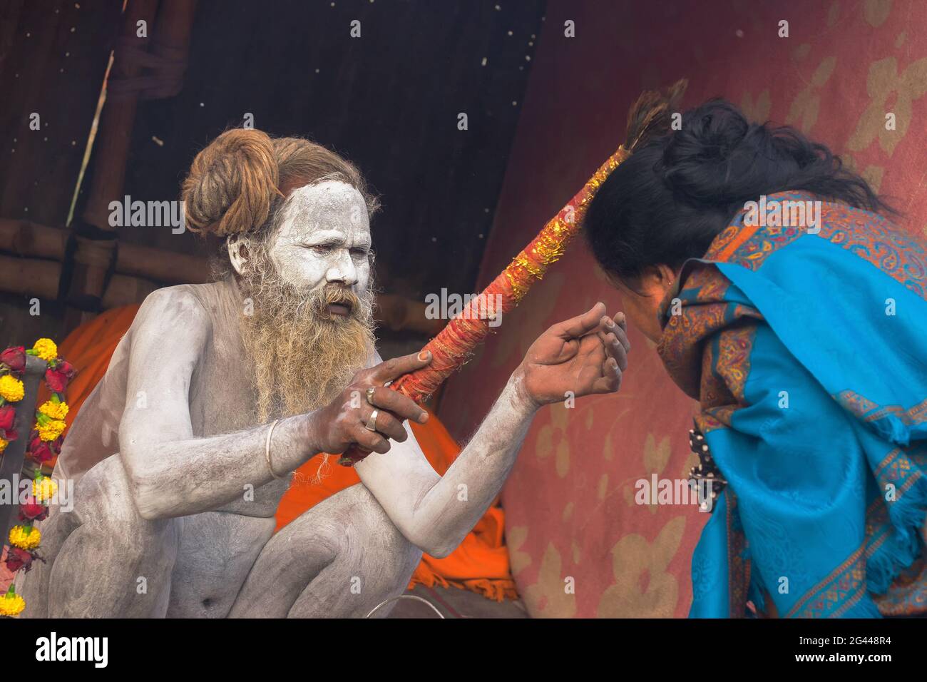 BABUGHAT, KALKUTTA, WESTBENGALEN / INDIEN - 11. JANUAR 2015 : Hindu-Sadhu mit weißer Asche auf Körper und Gesicht, die einen blauen, mit Sari bekleideten indischen Devoten segnet Stockfoto