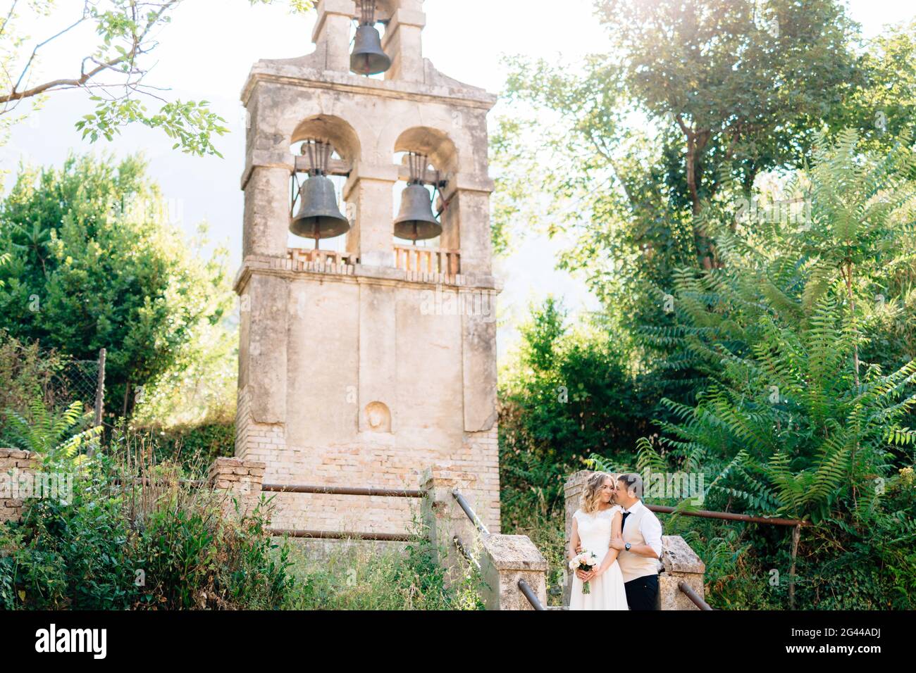 Die Braut und Bräutigam umarmen und küssen auf die alten Glockenturm in der Nähe der Kirche in Prcanj Stockfoto