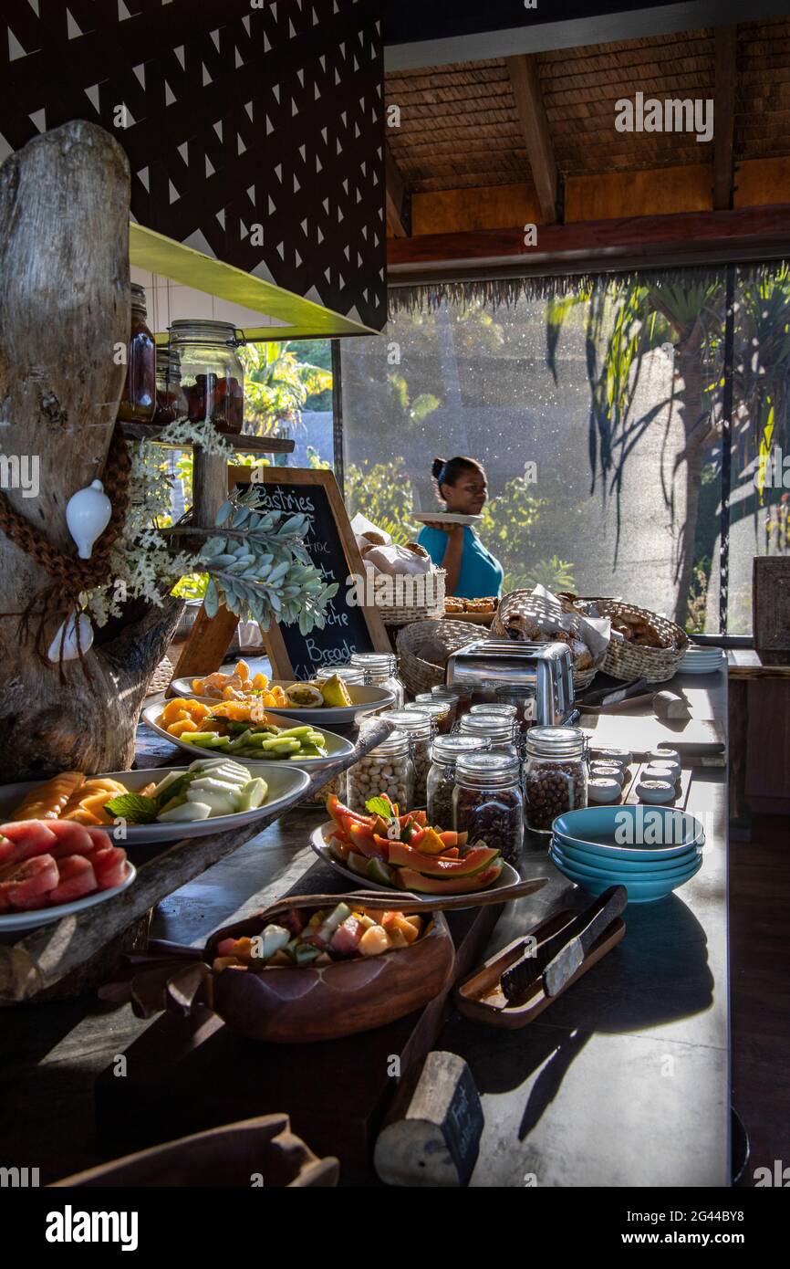 Kellnerin hinter einem fantastischen Frühstücksbuffet im Tovolea Restaurant des Six Senses Fiji Resort, Malolo Island, Mamanuca Group, Fiji Islands, Sou Stockfoto