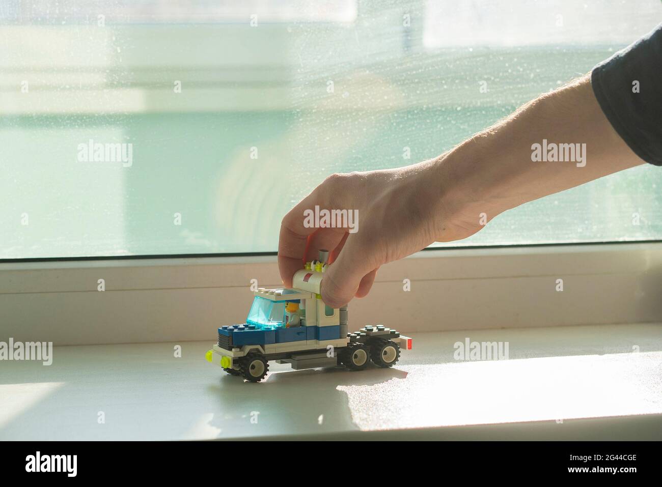 Hand hält ein Spielzeug Auto Konstruktor, aus Stücken Details Ziegel, Kreativität und Lernen Stockfoto