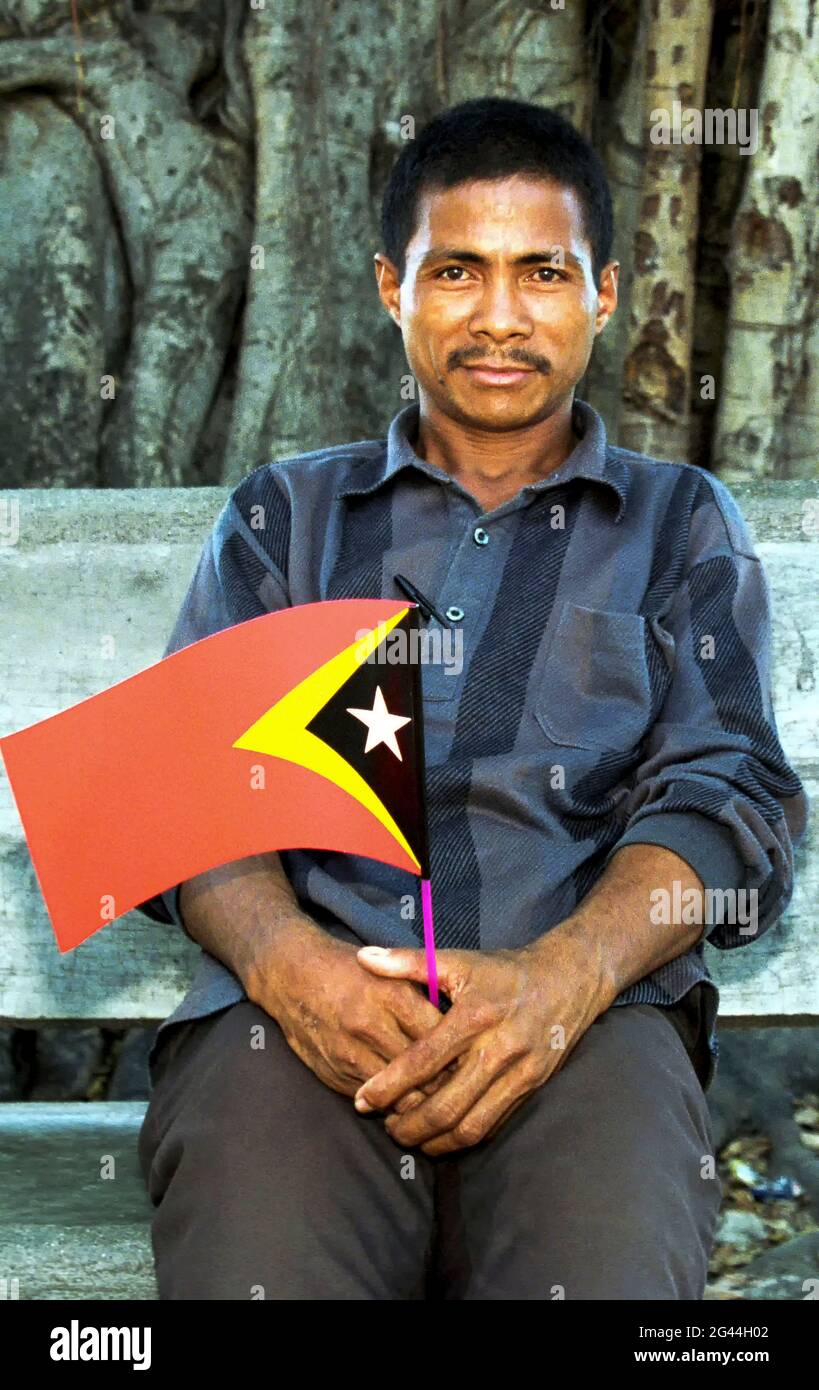 20. Mai 2002-Dili, Timor-Leste-in Diese Fotos entstanden am 7. Tag der Unabhängigkeit und dem Leben der Timoren in Dili und im Dorf Atambua. Ein Mann hält seine Nationalflagge im Park in Dili, Timor-Leste. Stockfoto