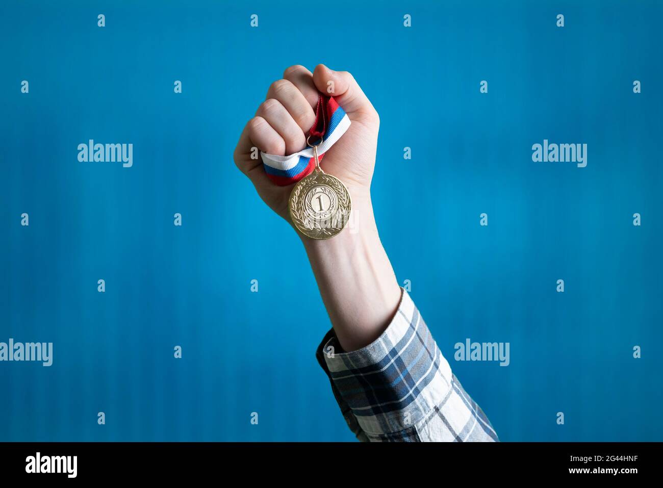 Person hob die Hand und gewann den ersten Platz, Hand halten Goldmedaille Stockfoto