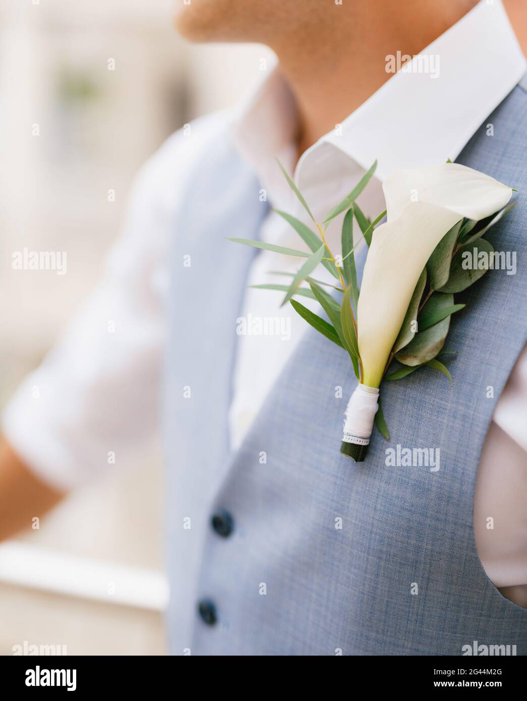 Der Bräutigam in Hemd und Weste mit Boutonniere steht am Morgen vor der Trauung aus nächster Nähe auf dem Balkon Stockfoto