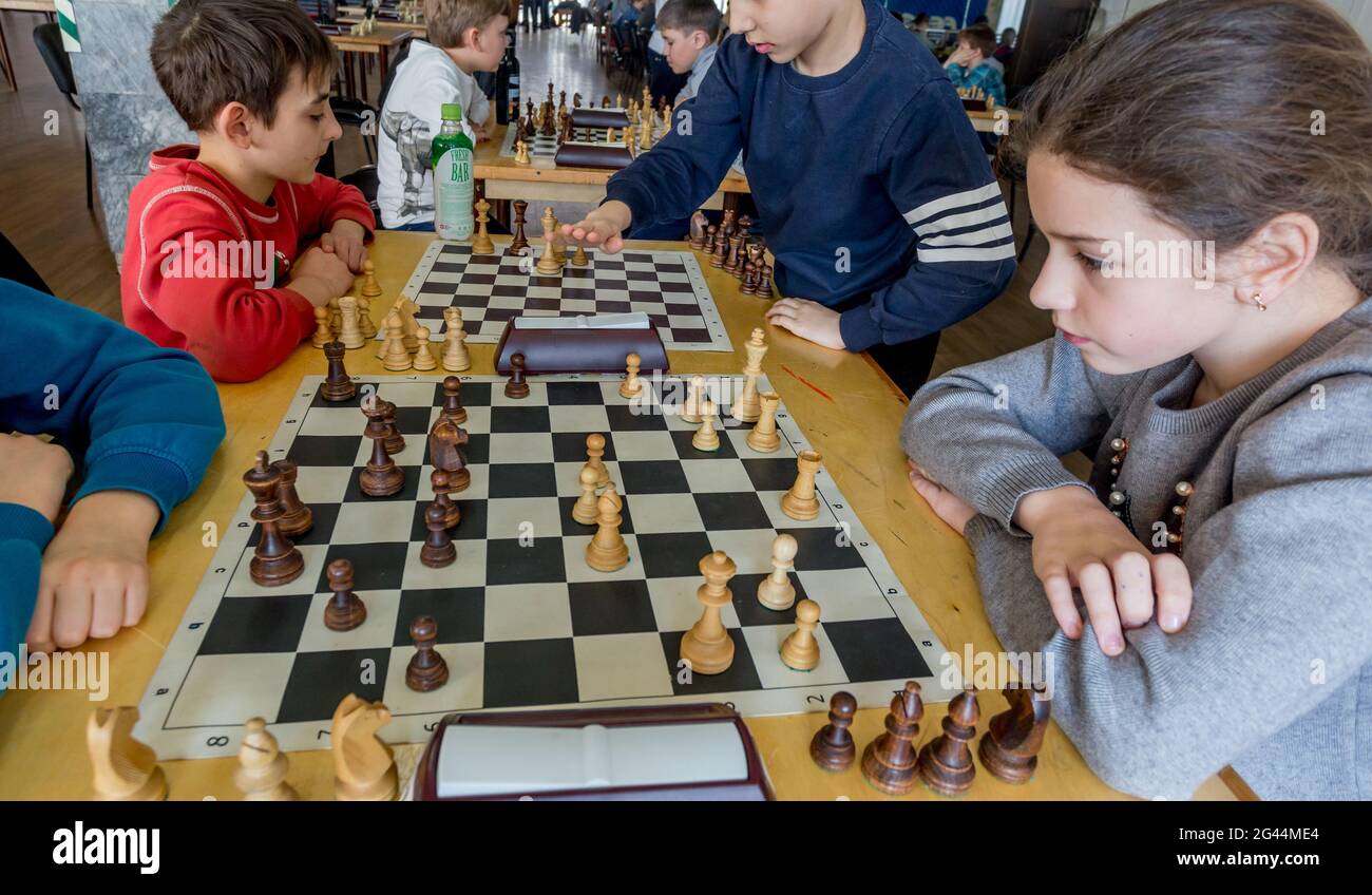 Russland, Wladiwostok, 02/24/2018. Kinder spielen Schach während des Schachwettbewerbs im Schachclub. Bildung, Schach und Gedankenspiele. Komet Stockfoto