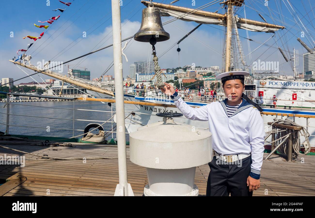 Russland, Wladiwostok, 07/28/2018. Porträt eines jungen Matrosen in offizieller Marine-Uniform auf dem Deck des Segelbootes. Konzept von mar Stockfoto