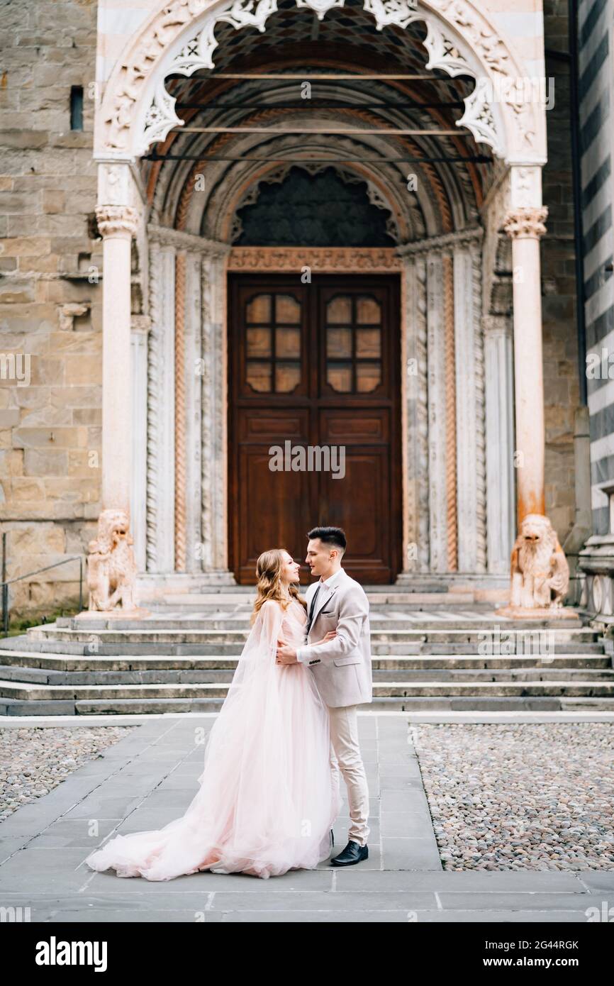 Brautpaar umarmen sich auf dem Hintergrund des Eingangs zur Basilika Santa Maria Maggiore, Rom, Italien Stockfoto