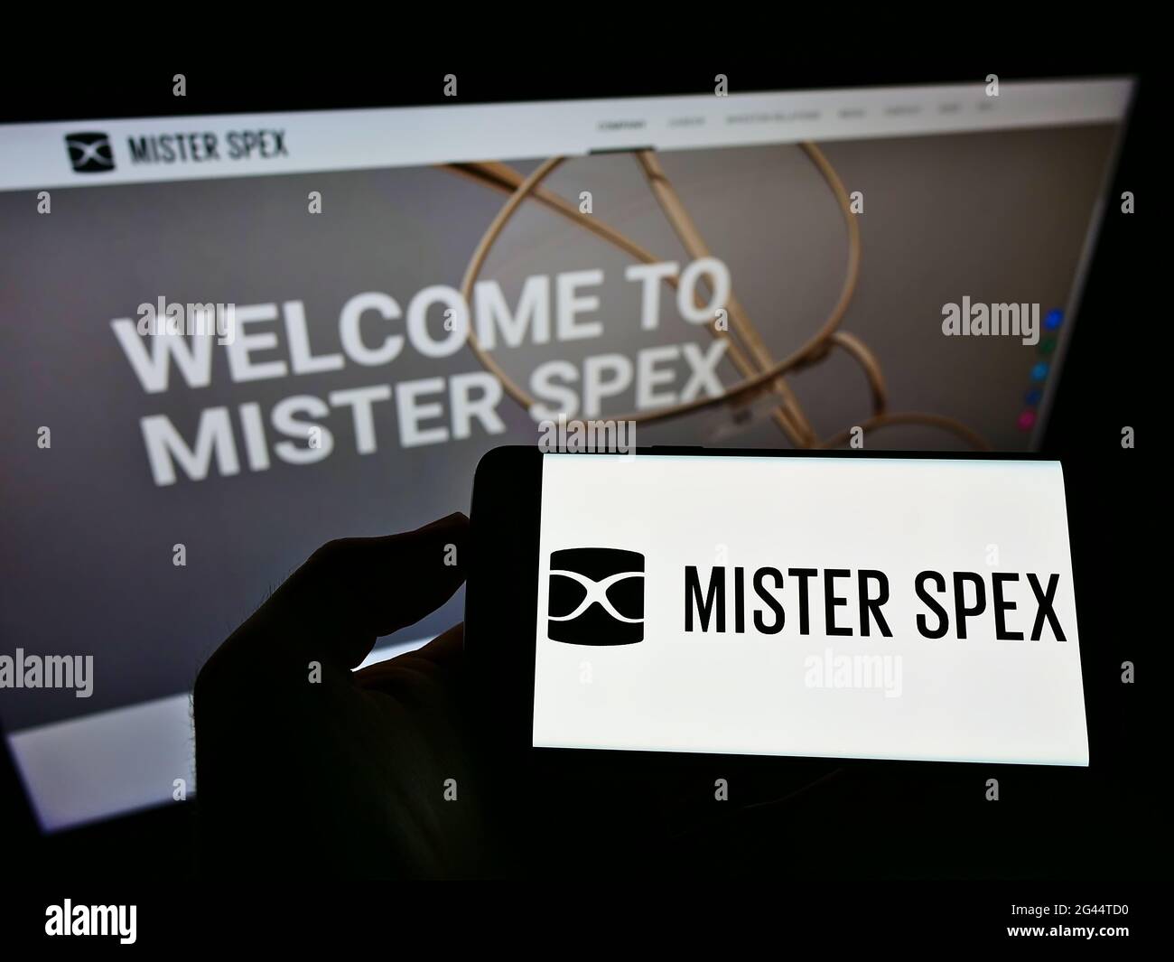 Person mit Mobiltelefon und Logo des deutschen Online-Optikers Mister Spex AG auf dem Bildschirm vor der Webseite. Konzentrieren Sie sich auf die Telefonanzeige. Stockfoto