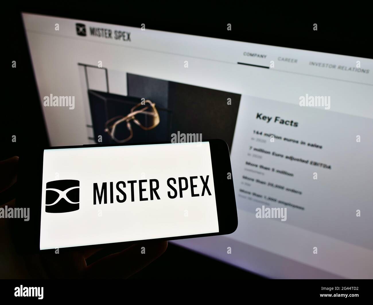 Person, die Mobiltelefon mit Logo des deutschen Online-Optikers Mister Spex AG auf dem Bildschirm vor der Business-Webseite hält. Konzentrieren Sie sich auf die Telefonanzeige. Stockfoto