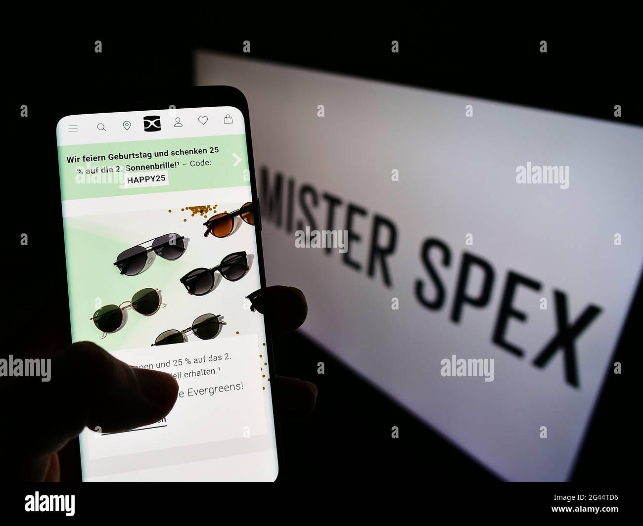 Person mit Mobiltelefon mit Website des deutschen Online-Optikers Mister Spex AG auf dem Bildschirm mit Logo. Konzentrieren Sie sich auf die Mitte des Telefondisplays. Stockfoto