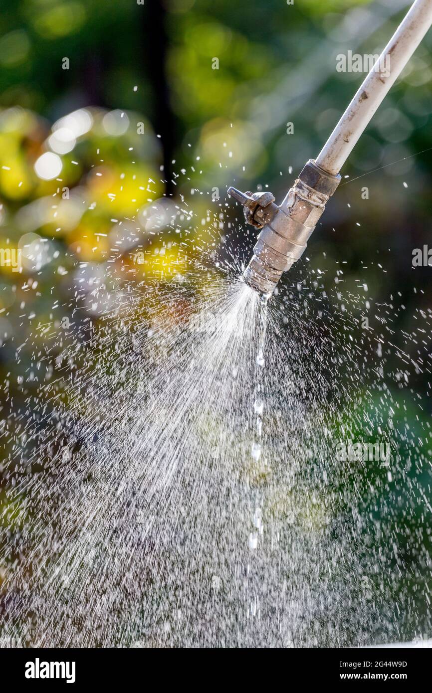 Alter Wasserhahn mit Ventil, das Wasser austritt. Schöne Wassertropfen und schöner Hintergrund. Stockfoto