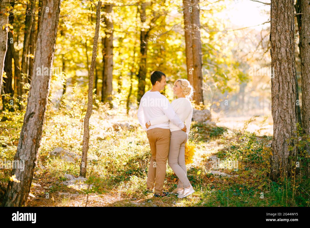 Mann und Frau umarmen sich im Herbstwald. Rückansicht Stockfoto