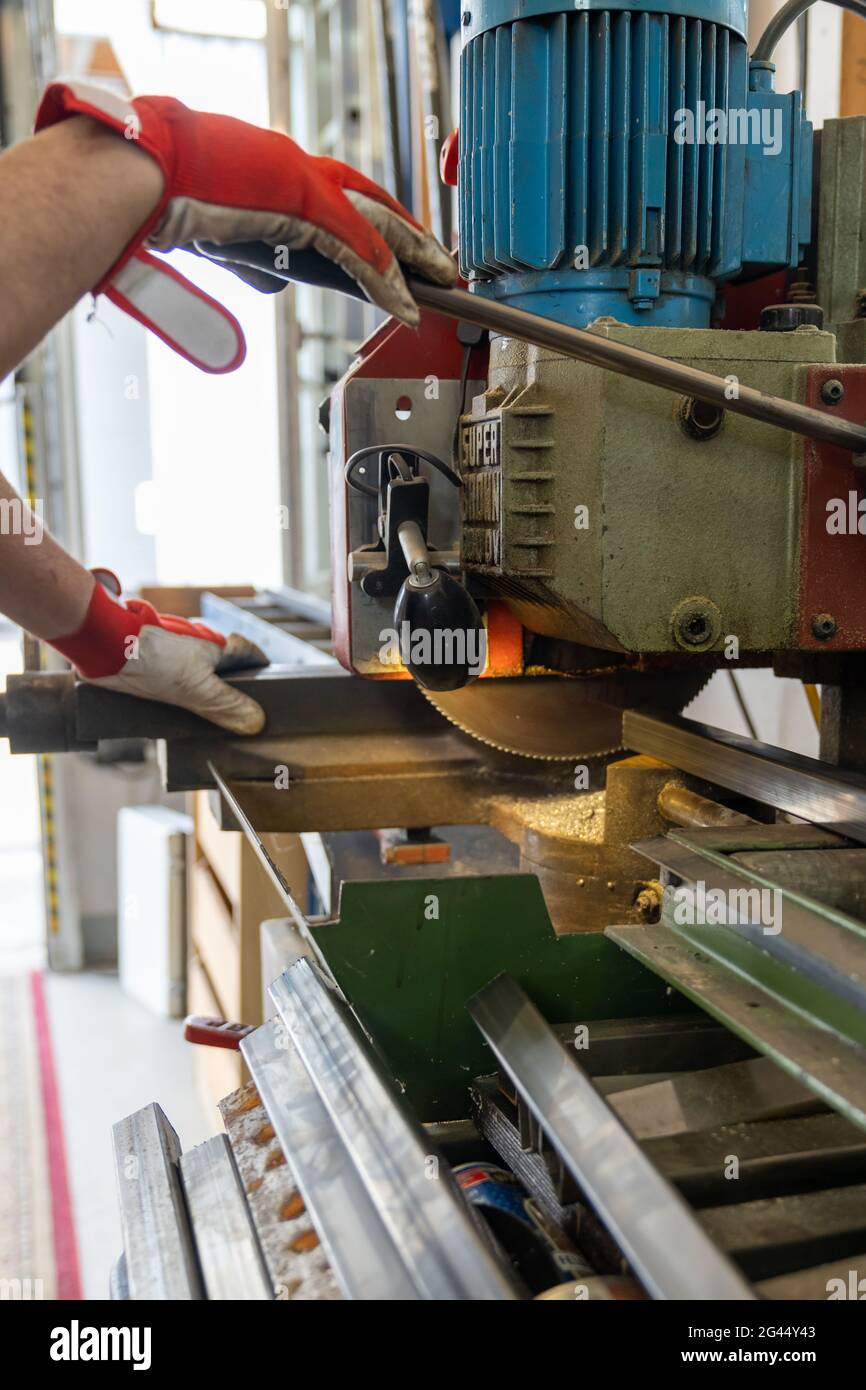 Metallarbeiter schneidet Stahl mit einer Stahlbandsäge Stockfoto