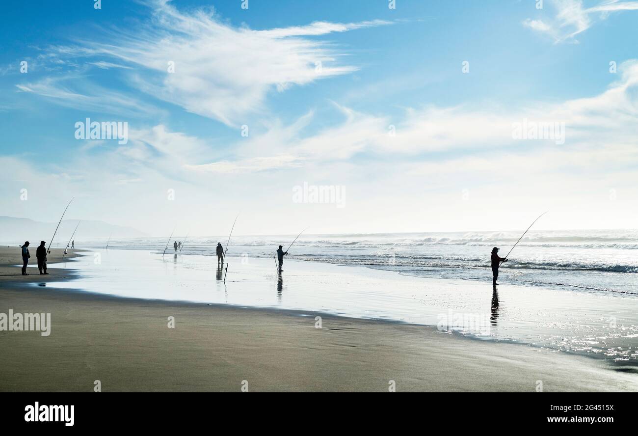 Gruppe von Fischern am Strand unter blauem Himmel Stockfoto