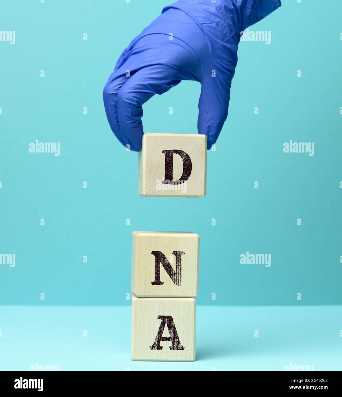 Abkürzung DNA auf quadratischen Holzblöcken, blauer Hintergrund Stockfoto