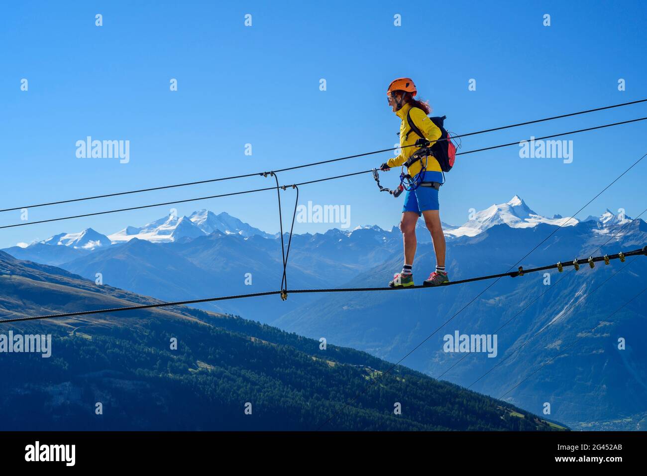 Frau auf dem Gemmi Abenteuer Klettersteig geht über Seilbrücke, Walliser Alpen mit Dom und Weisshorn im Hintergrund, Gemmi, Berner Alpen, Wal Stockfoto