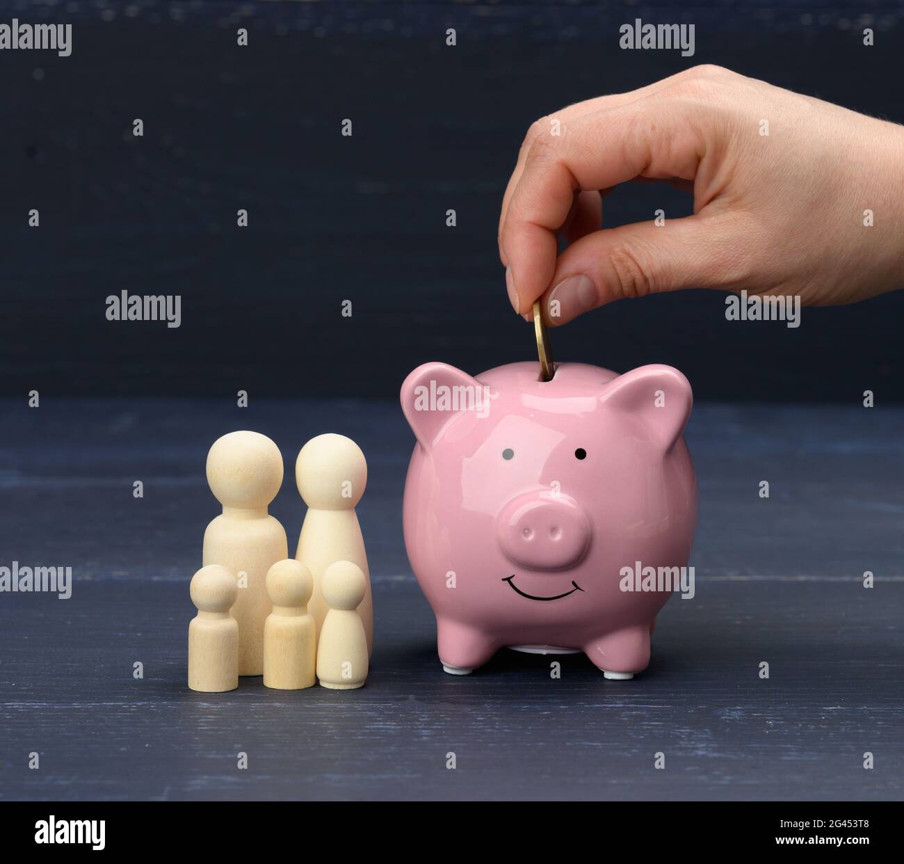 Holzerne Familienfiguren Und Rosa Keramik Sparschwein Auf Blauem Hintergrund Konzept Der Anhaufung Von Bargeld Fur Den Kauf Eines Hauses Und Eines Autos Geld In Der Bank Stockfotografie Alamy