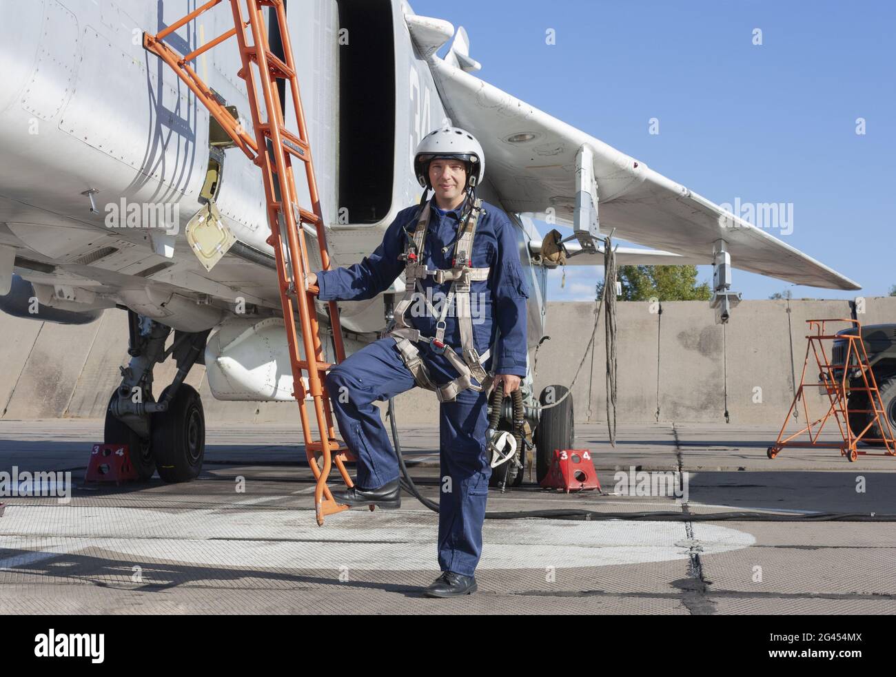 Militärpilot im Helm steht in der Nähe von Jet-Flugzeug Stockfoto