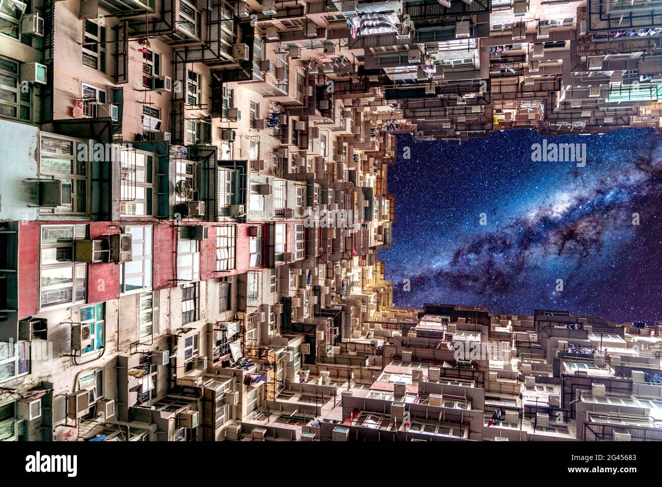 Der Himmel der Nachtgalaxie über dem Berghaus in der Nähe von Tai Koo in Hongkong. Überfülltes altes Retro-Gebäude Stockfoto