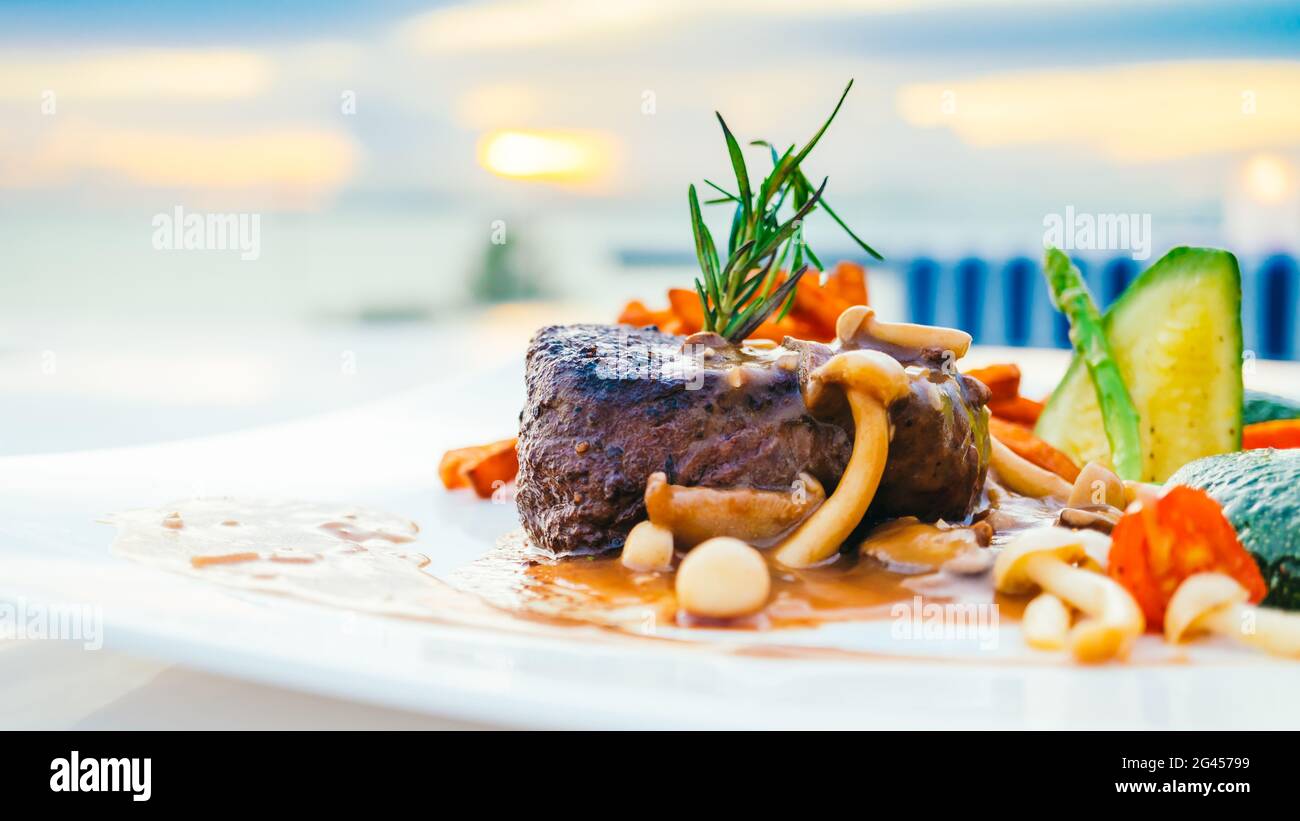 Gegrilltes Rinderfilet Fleischsteak mit Gemüse in weißer Platte - Farbfilterverarbeitung Stockfoto