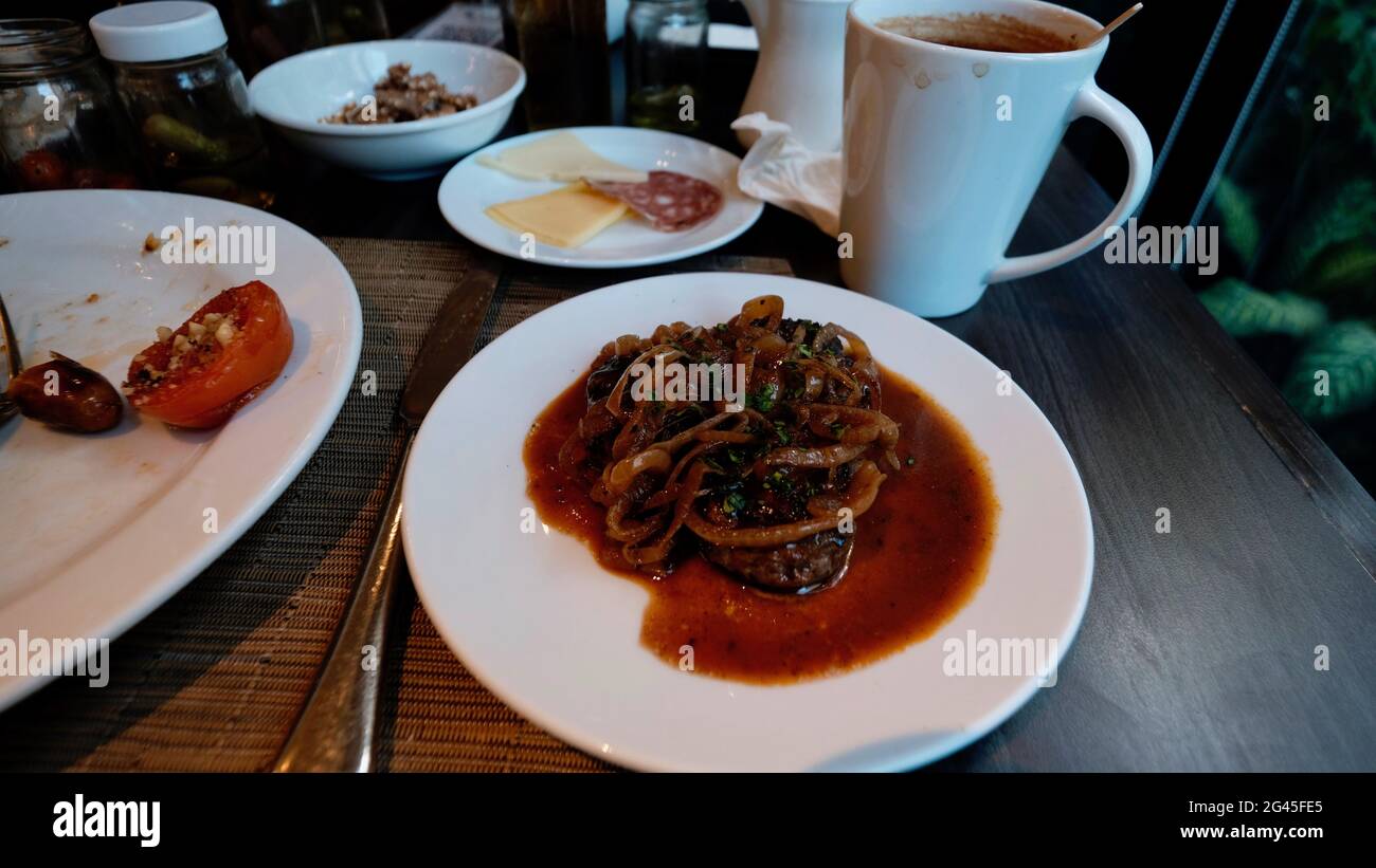 Frühstücksbuffet Essen Hamburger mit gebratenen Zwiebeln und Soße Stockfoto