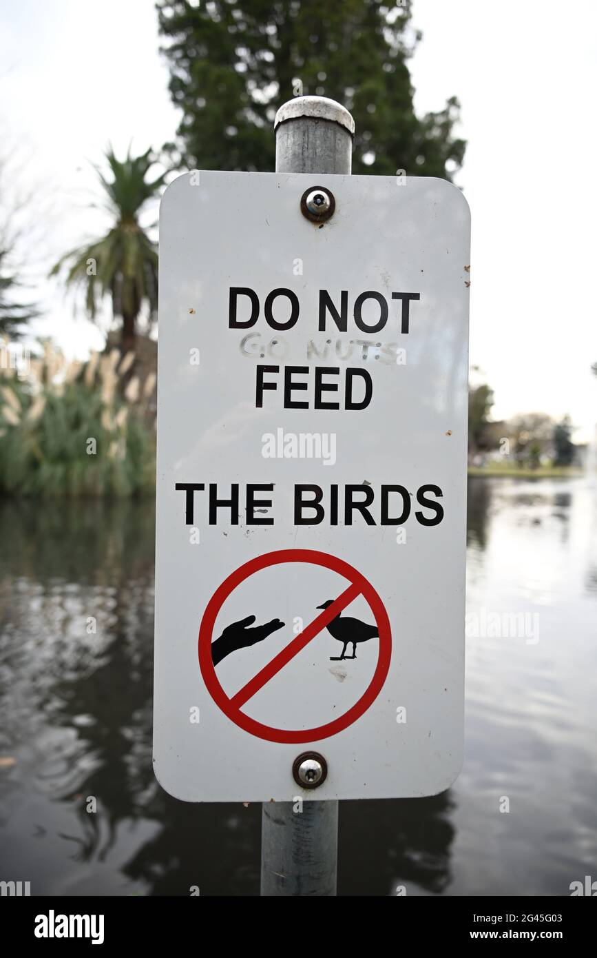 Ein Schild, das die Menschen davor warnt, die Vögel zu füttern, geschickt verändert, um das Füttern zu fördern Stockfoto