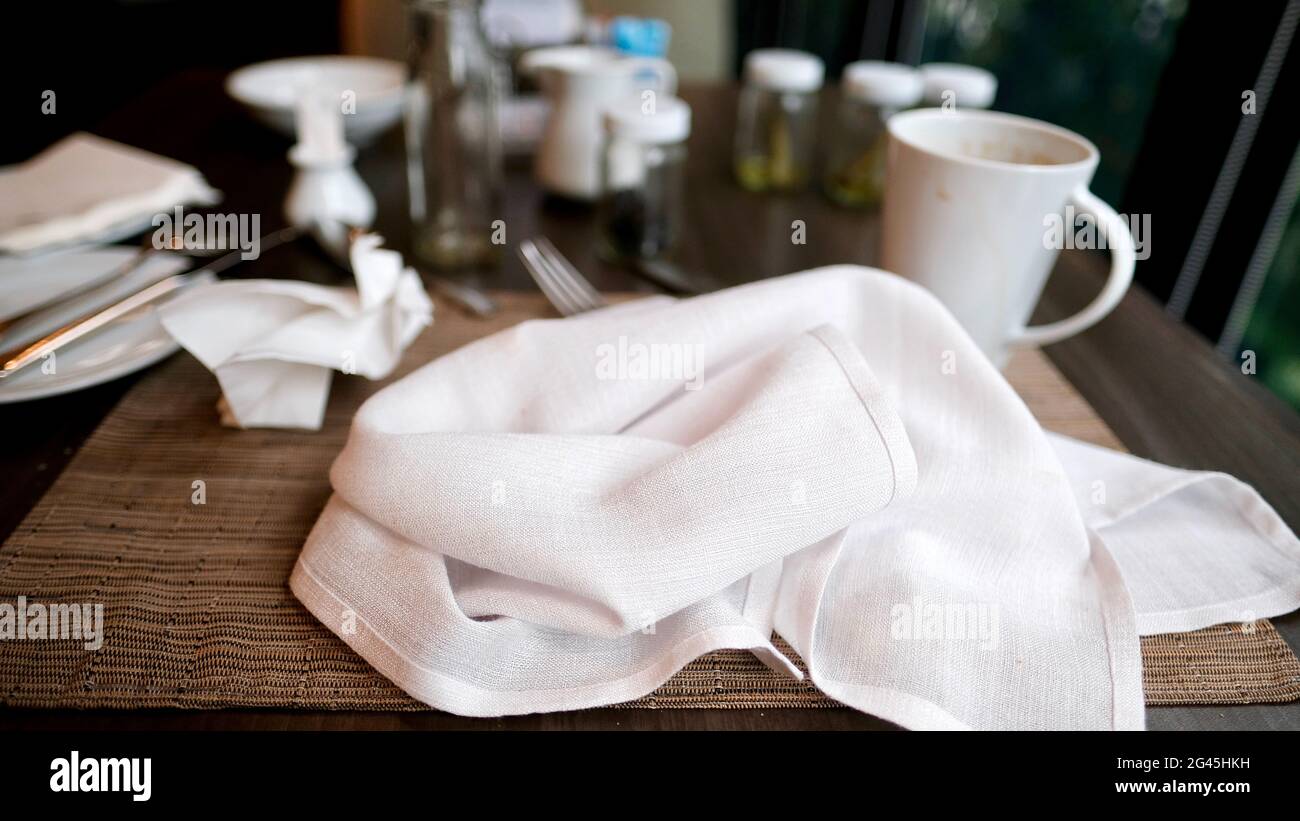 Die Serviette auf dem unordentlichen Tisch verschwimmte den Hintergrund, während die Kaffeetasse fertig war, ein Tuch und ein Handtuch zu essen, um die Rechnung zu bezahlen Stockfoto