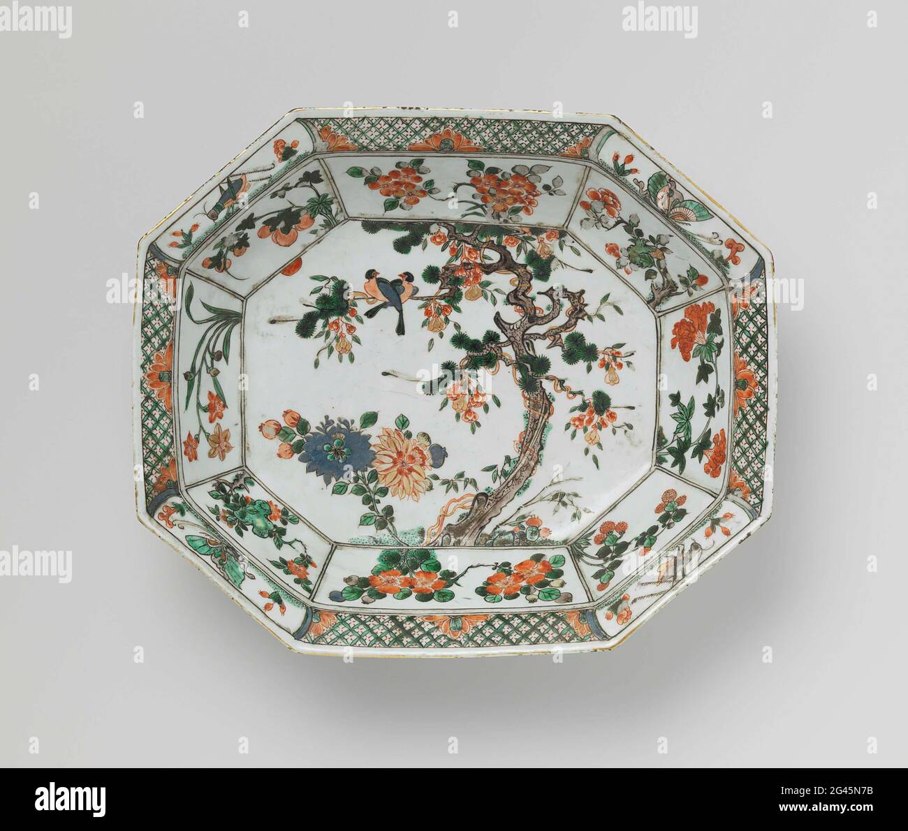 Längliches, achteckiges Becken mit Blumen, Vögeln und Insekten. Achteckige, tiefe, längliche Schale aus Porzellan auf der Glasur in blau, rot, grün, gelb, Auberginen gemalt, Schwarz und Gold mit einer Handelsdekoration, gefüllt mit Blumen und Tieren. Auf der Wohnung ein Baum mit blühenden Pflanzen und zwei Vögeln; die Wand innen und außen mit vier großen Fächern gefüllt mit blühenden Pflanzen, durchsetzt mit kleineren Fächern mit Mehl und Obstsorten; Der Rand mit geometrischem Motiv durchsetzt mit Mehlrosetten mit Kartuschen mit Insekten innen und außen Kartuschen mit Fischen Stockfoto