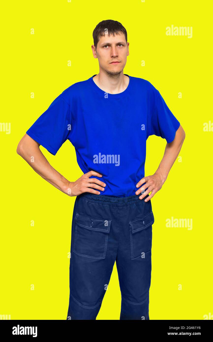 Werbung für Arbeitskleidung. Ein ernsthafter und selbstbewusster junger Mann mit kaukasischem Aussehen. Isoliertes Porträt auf gelbem Hintergrund. Stockfoto