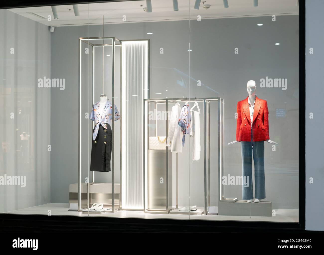Fenstervitrine im Laden mit Manequins, die neue Kleidung zeigen Stockfoto