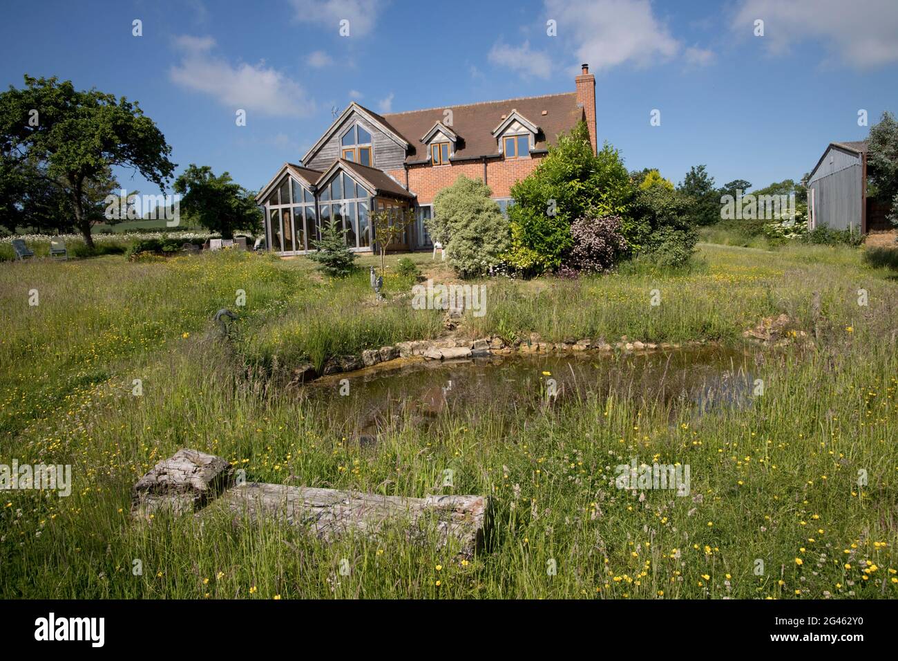 Preisgekröntes Null-Energie-Ökohaus in Eichenrahmen mit Betonwänden und dreifach verglasten Fenstern, die in Cotswolds, Großbritannien, auf Passivplatten gebaut wurden Stockfoto