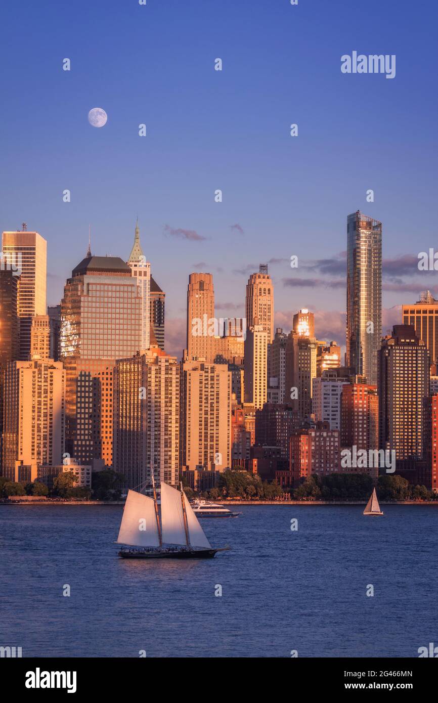 Vollmond steigt über Lower Manhattan in der Golde Hour auf Stockfoto