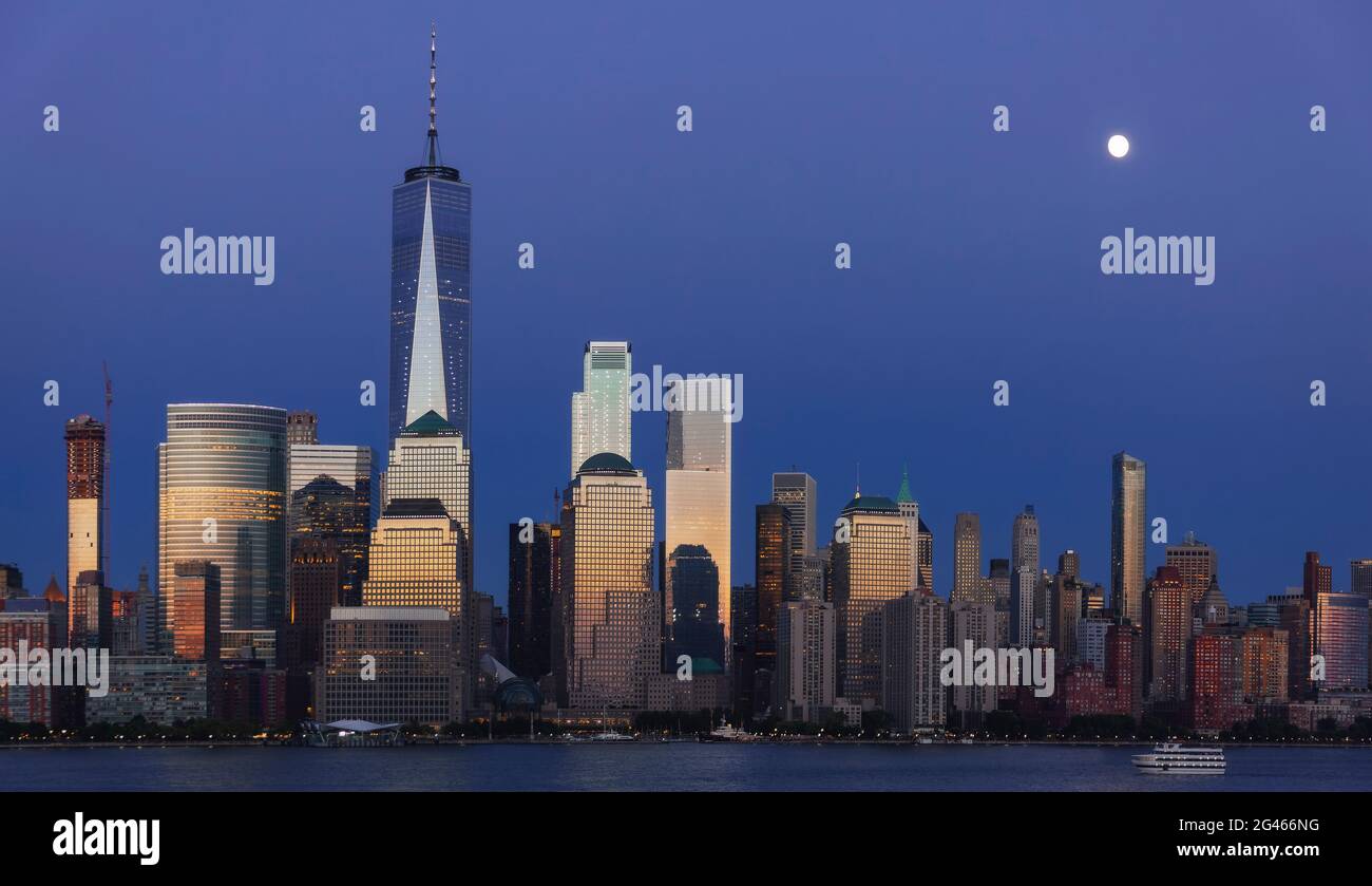 Vollmond, der zur Blauen Stunde über Lower Manhattan aufsteigt Stockfoto