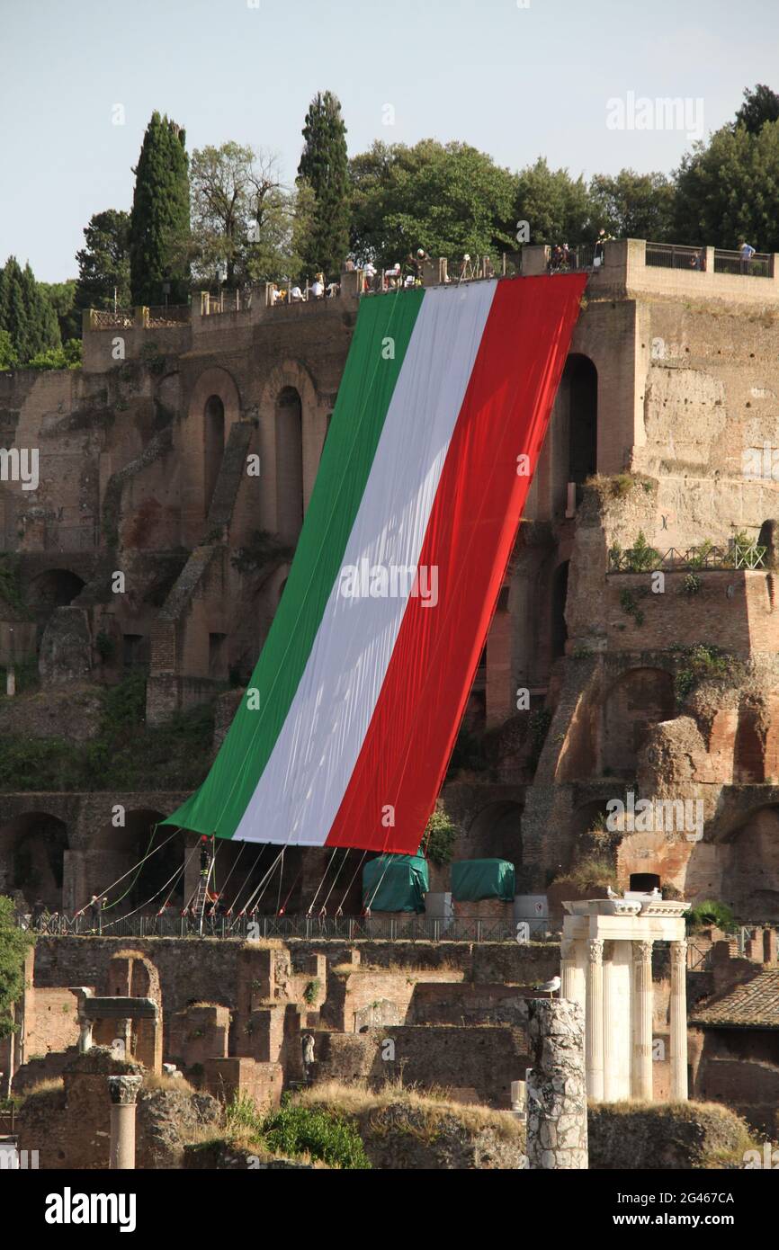 Die Feuerwehr rollt die italienische Flagge vom Palatin in Rom ab, um das Konzert der Feuerwehr-Kapelle im Orti Farnesiani zu feiern Stockfoto